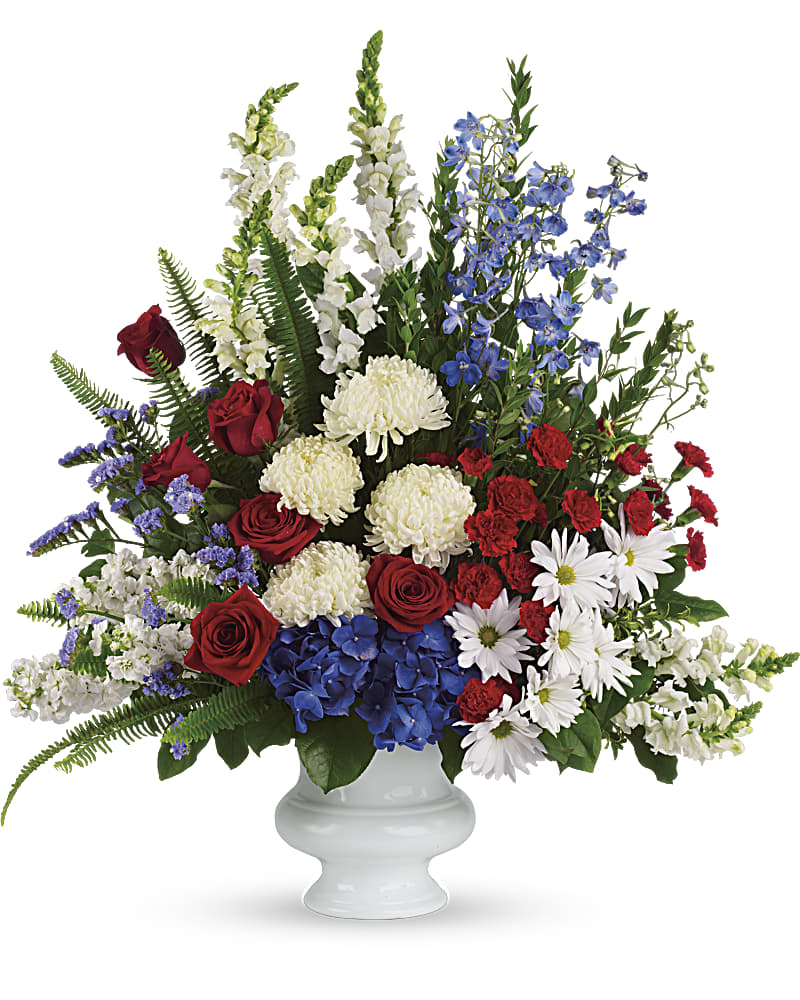 Red roses, white daisies, and blue flowers in a white vase