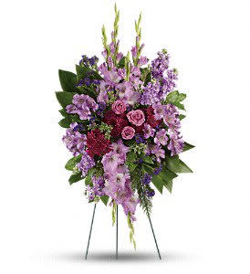 Standing floral spray with purple and pink flowers on a wire easel