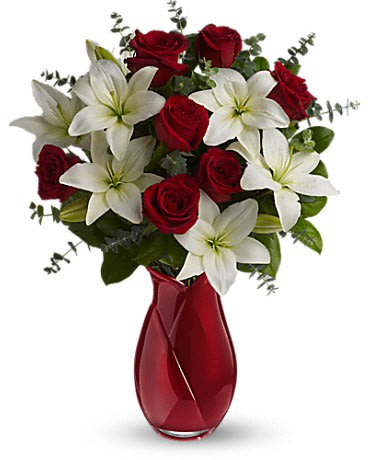 Red roses and white lilies in a red glass vase