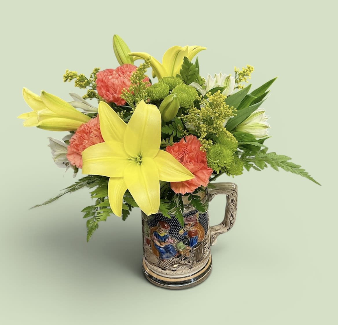 Three Cheers for Flowers - A beautiful mix of yellow Lilies, green Buttons, orange Carnations, white Alstroemeria and Solidago come together in a vintage beer stein. The perfect gift for your dad, husband, brother, or anyone who enjoys the unique.