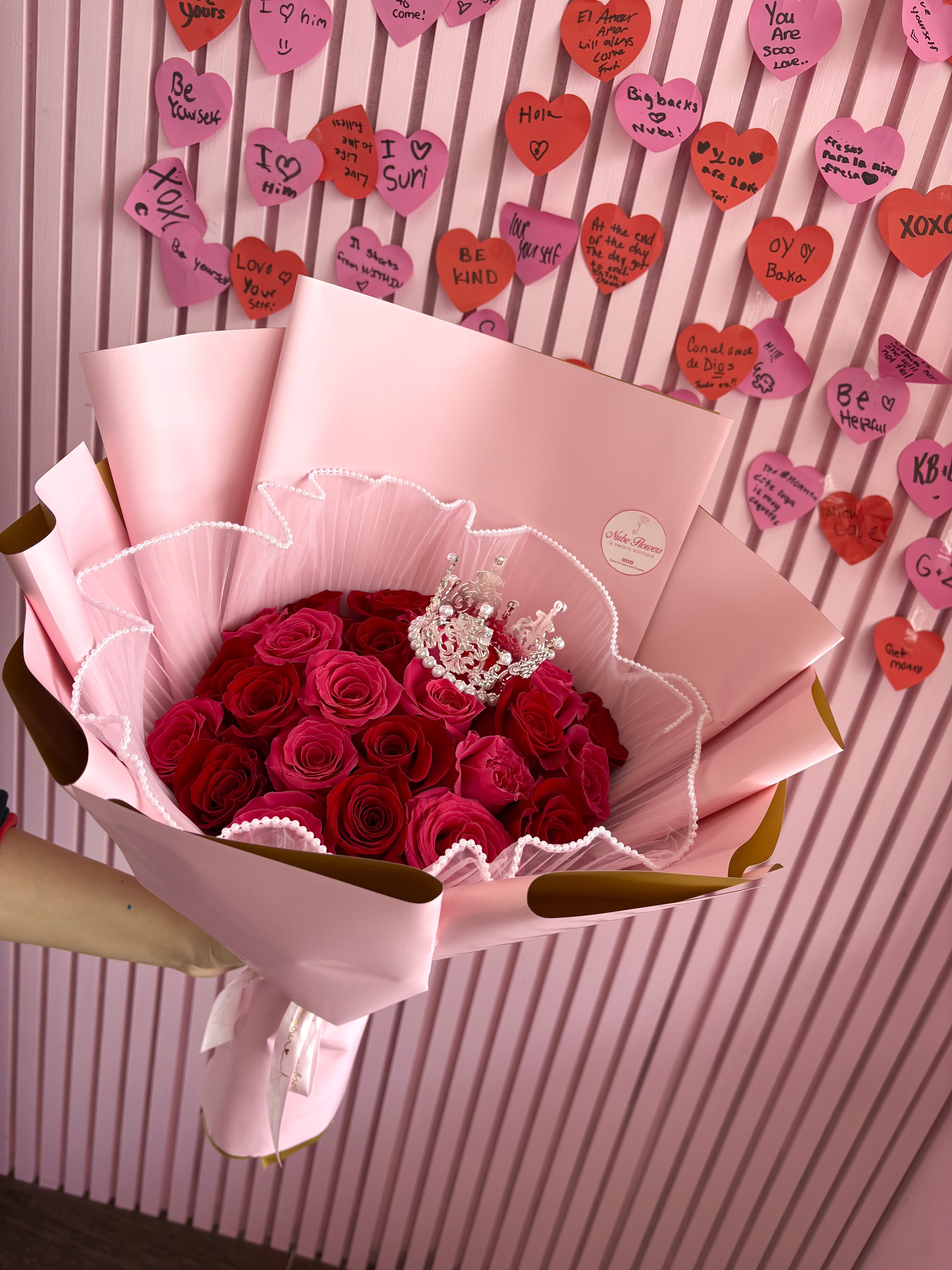 Bouquet of red and pink roses wrapped in pale pink paper