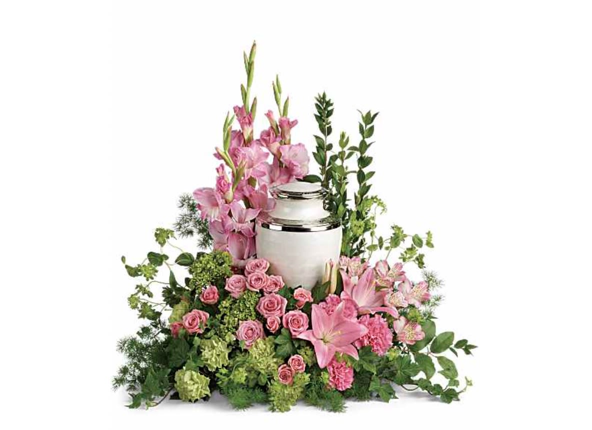 Pink floral arrangement around a silver urn