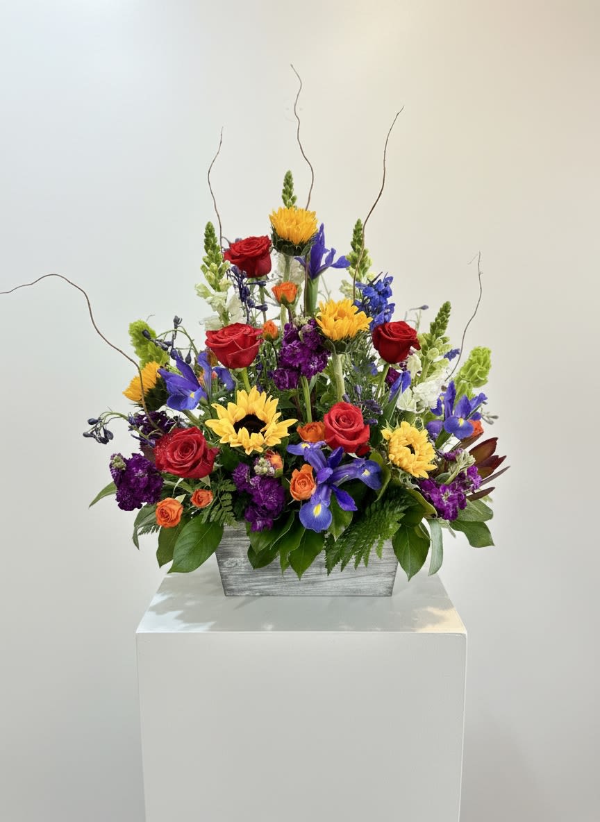A Beautiful Life - Honor a life beautifully lived with this vibrant floral tribute that celebrates cherished memories and the lasting impact of someone special. Arranged in a whitewashed box, this colorful display of fresh blooms offers a heartfelt expression of sympathy while reflecting the joy, warmth, and beauty of a life well lived. Includes roses, sunflowers, irises, stock, spray roses, snapdragons, and bells of ireland.  Please Note: Standard Delivery for this product occurs in the afternoon, between 2:30pm and 7pm. If you need it by a certain time, there is an option to select a timed window for scheduled deliveries.  Please let us know in the "Special Instructions" section what time the viewing or funeral services start to ensure a timely delivery.