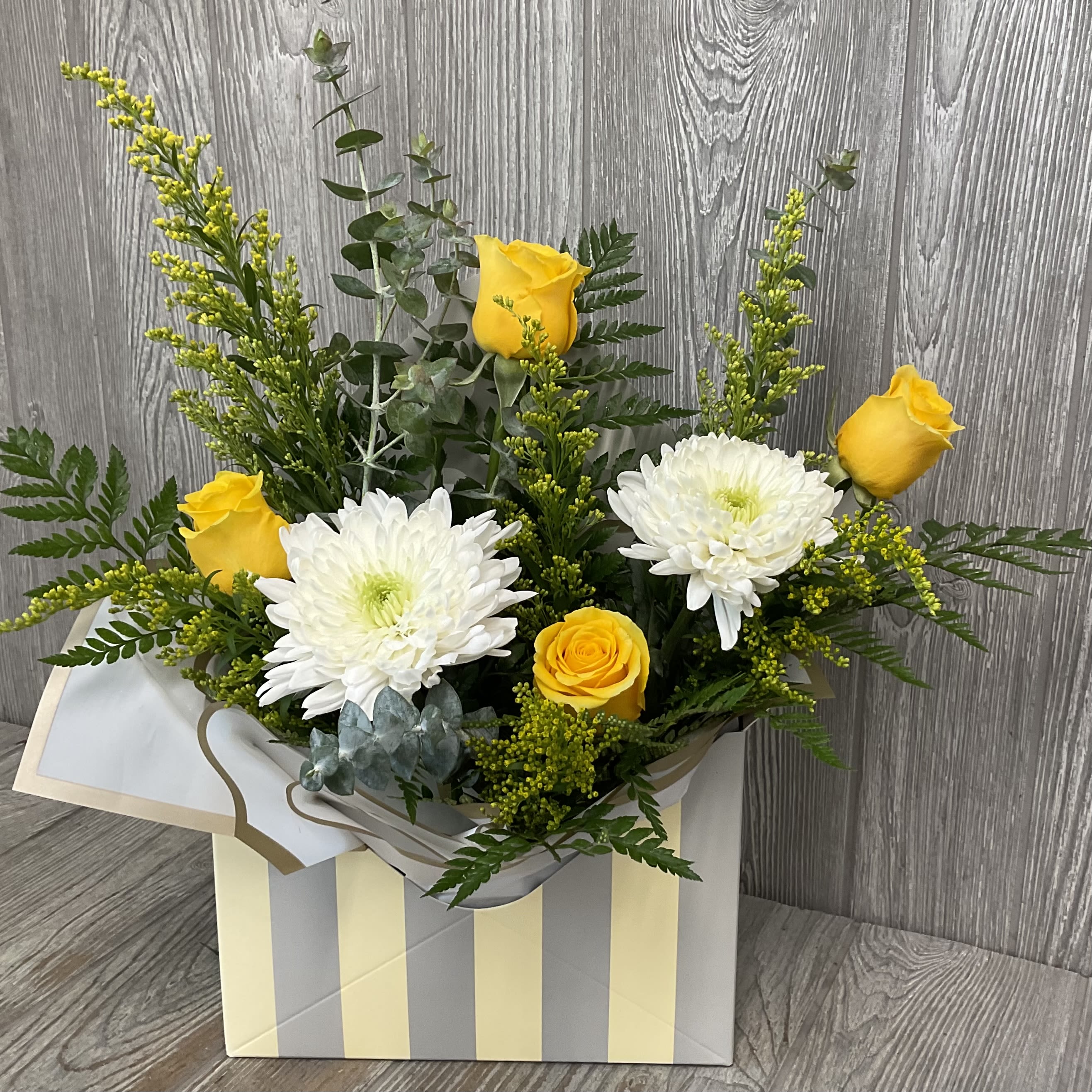 Letters to Mom - Yellows - A beautiful arrangement of fresh cut flowers arranged in an envelope style container. Perfect to send some love with this Mother’s Day! Flowers and colors may vary, envelope style container in assorted yellows. 