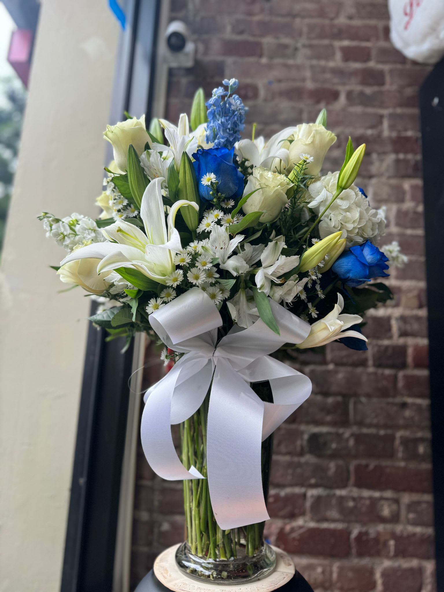 Designer's Choice Blue &amp; White - An all white and blue bouquet is designed by experienced designers including mixed blooms of the best quality available in stock in our choice of container! The design you receive will be unique to you - it will not match the image here as it's just an example of a designer's choice design that we've sent out!