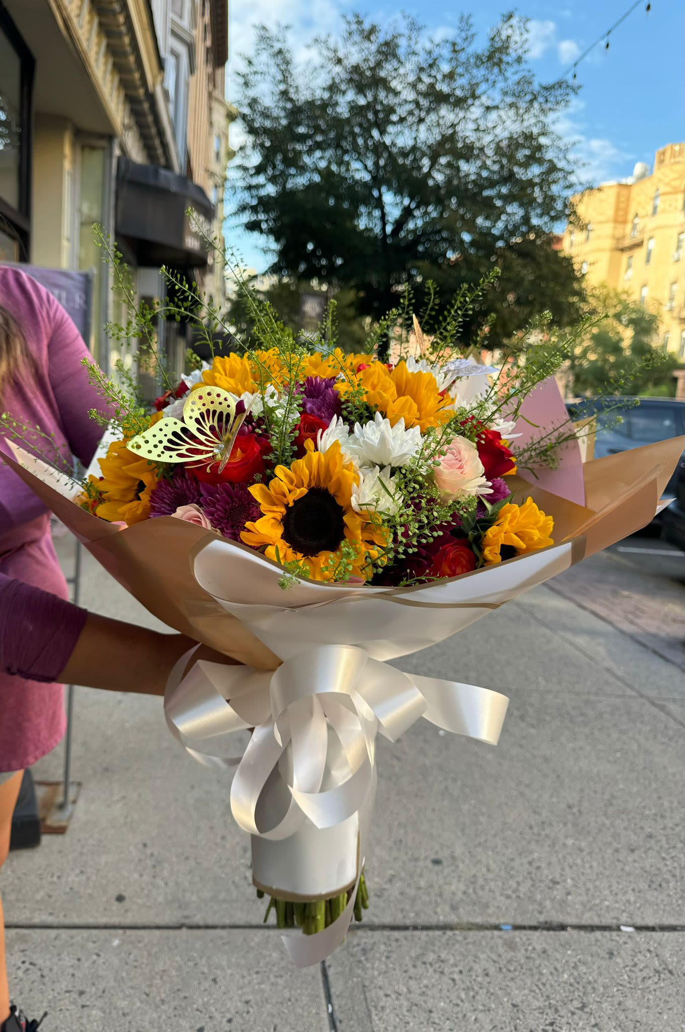 Golden Glow  - Golden Glow is a vibrant and warm bouquet that combines the majesty of golden sunflowers with the elegance of orange roses. This floral arrangement captures the essence of a glowing sunset, radiating a soft and welcoming light. The warm shades of yellow and orange evoke feelings of joy, energy and optimism, making Golden Glow the perfect gift to brighten up any space or to express a message of gratitude and affection