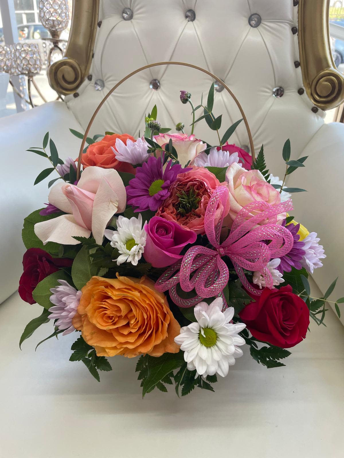 Mixed bouquet of roses and daisies with a pink ribbon bow