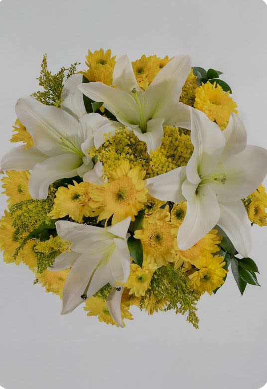 White lilies and yellow daisies in a round bouquet