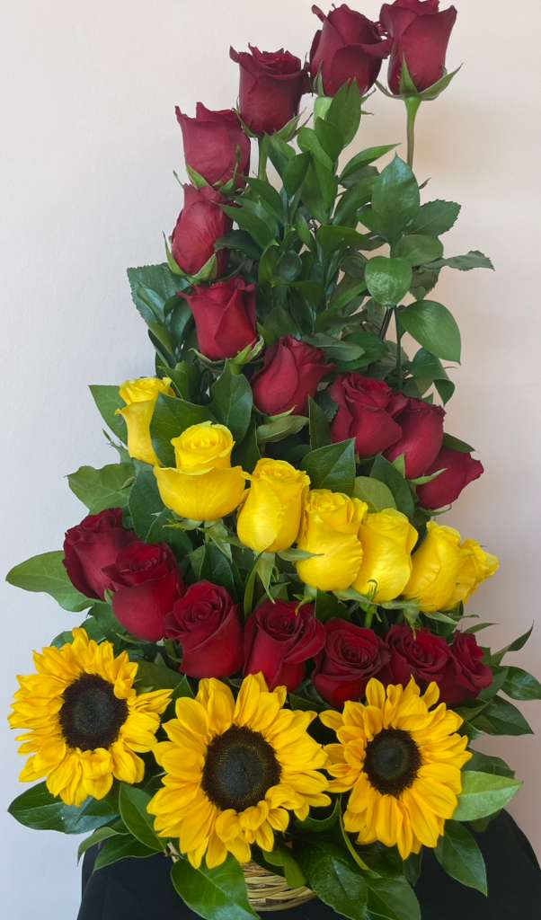 Tall basket arrangement of red and yellow roses with sunflowers