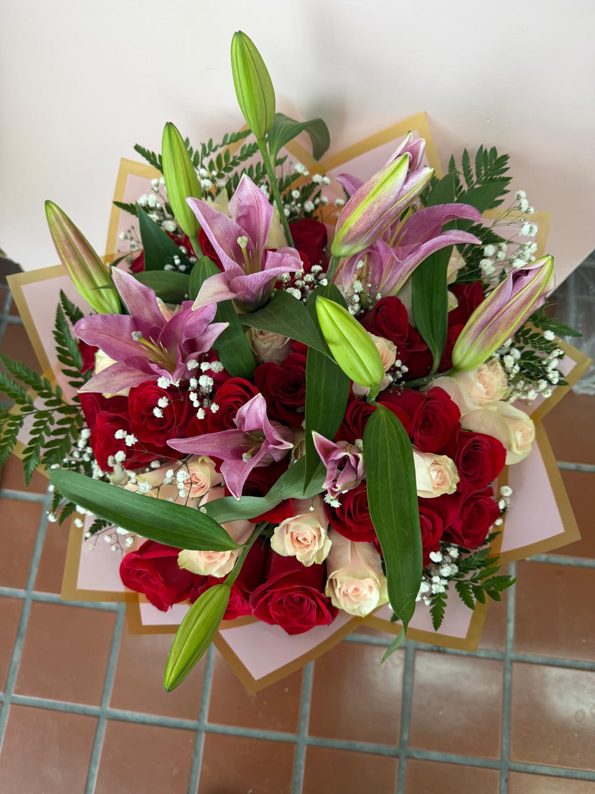 Bouquet of red and cream roses with pink lilies