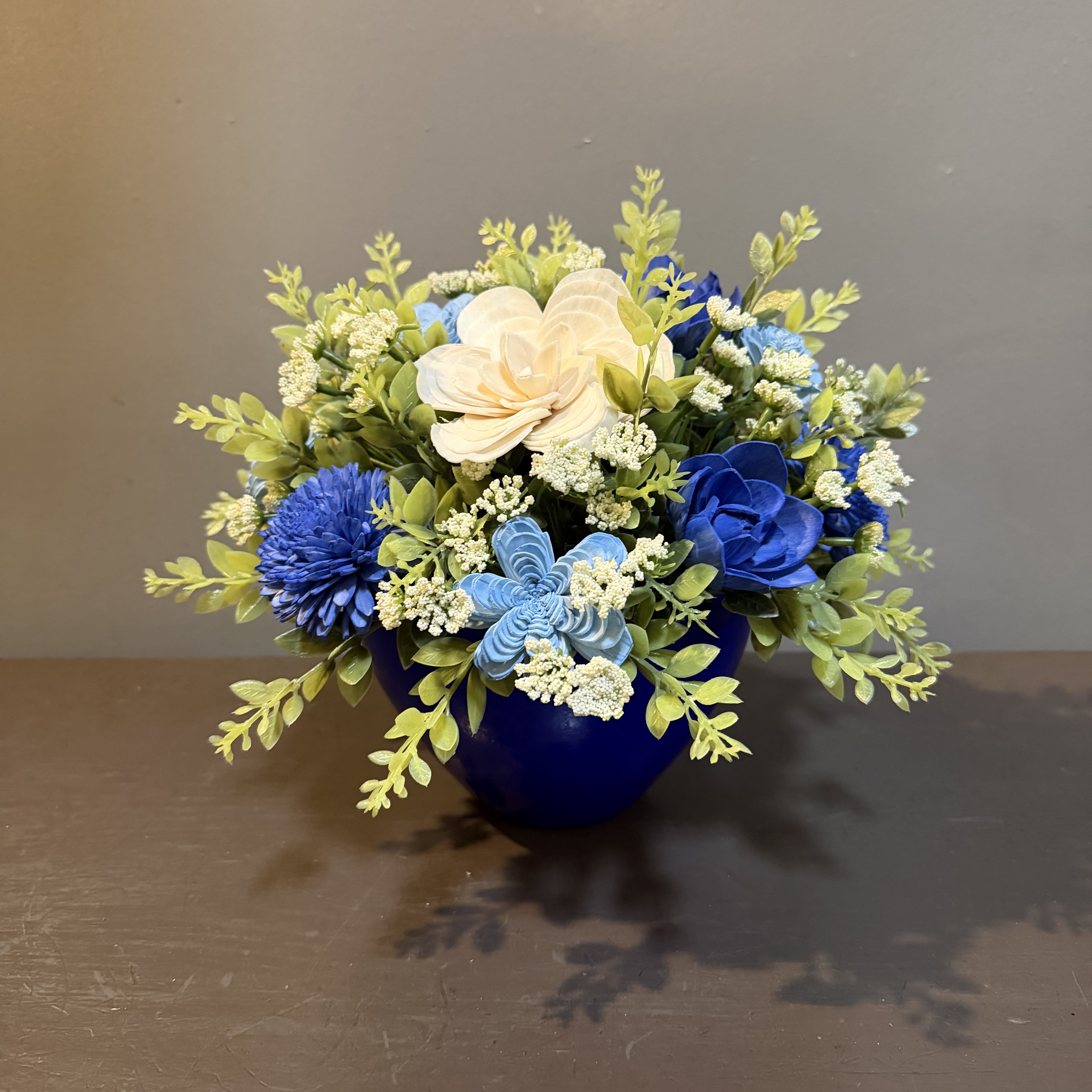 Sola Wooden Flower Centerpiece - Goodness and Light - Hand-dyed and hand-crafted in Minneapolis, these flowers made of balsa wood are a wonderful everlasting floral arrangement - great for those with allergies! Can be used as a natural essential oil diffuser too! Arrives in a keepsake blue vase. Approx. Dimensions: 11"Tx11"W