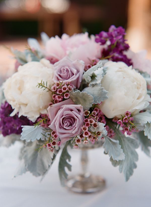 Lavender roses and white peonies in a low bouquet with silver foliage