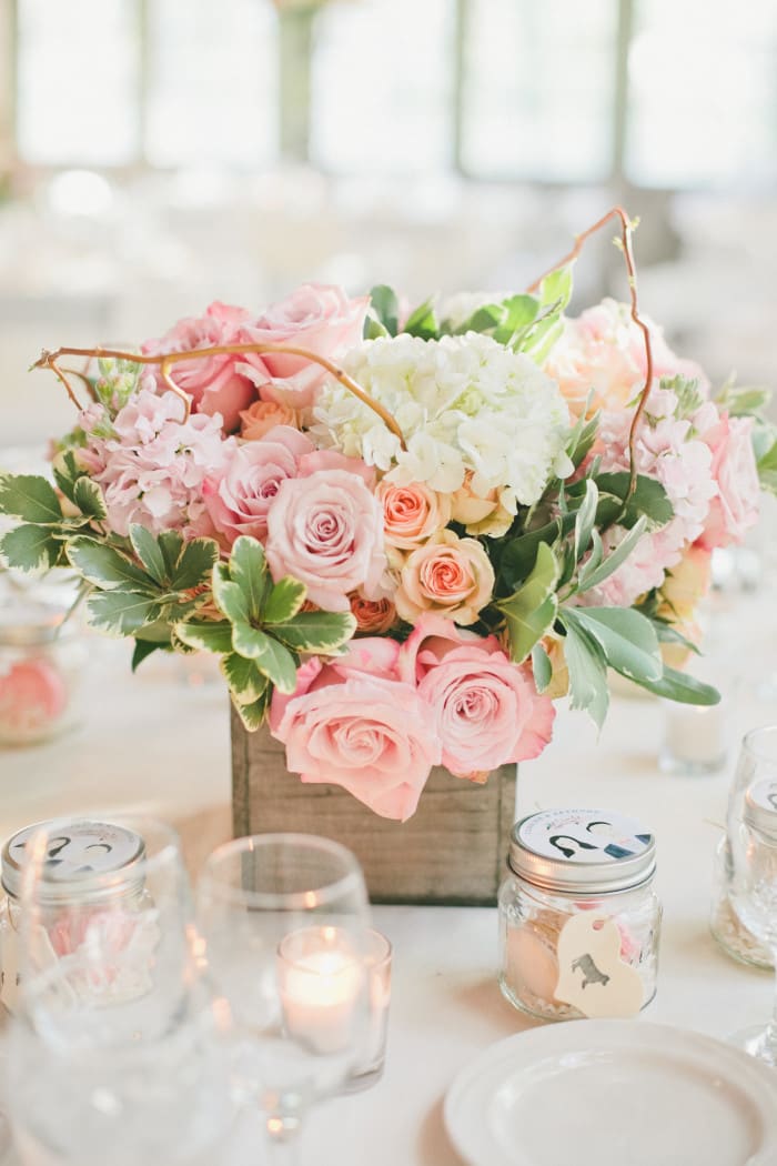 Pink and white floral centerpiece in a wooden box on a table