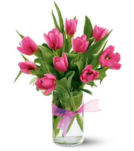 Pink tulips in a clear glass vase with a pink ribbon
