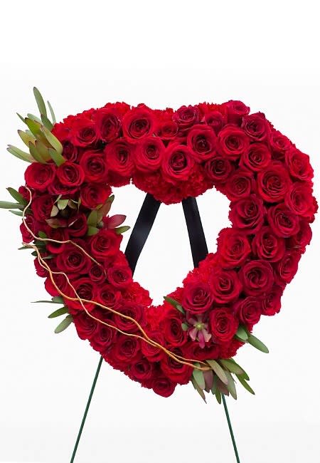 Heart-shaped red rose wreath on a stand