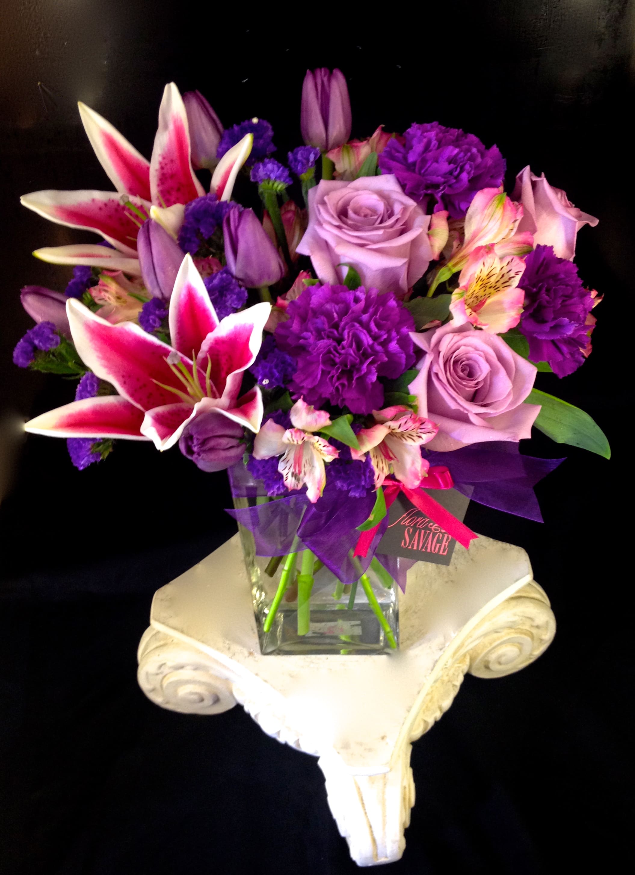 Purple and pink mixed bouquet in a clear glass vase