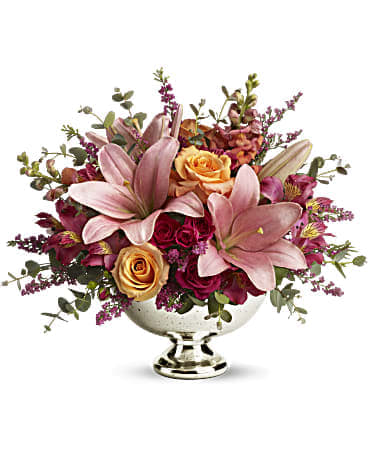 Pink lilies and roses arranged in a silver pedestal bowl