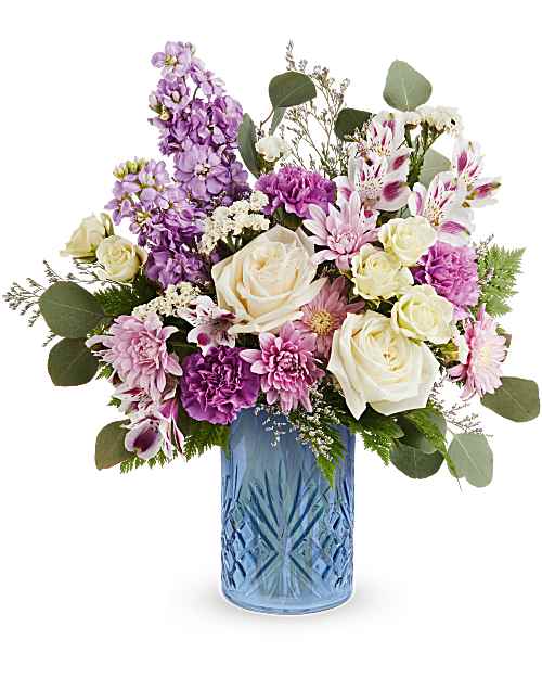 Blue Bliss - Soft, romantic pastels arranged in a cool blue vase make this birthday bouquet or get-well gift feel quietly special. The Blue Biss birthday bouquet (also perfect for anniversaries or gentle sympathy) pairs creamy ivory roses with lavender stock and purple carnations so the recipient feels both comforted and celebrated. 