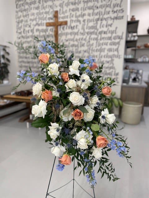 Standing floral spray with white and peach roses and blue accents