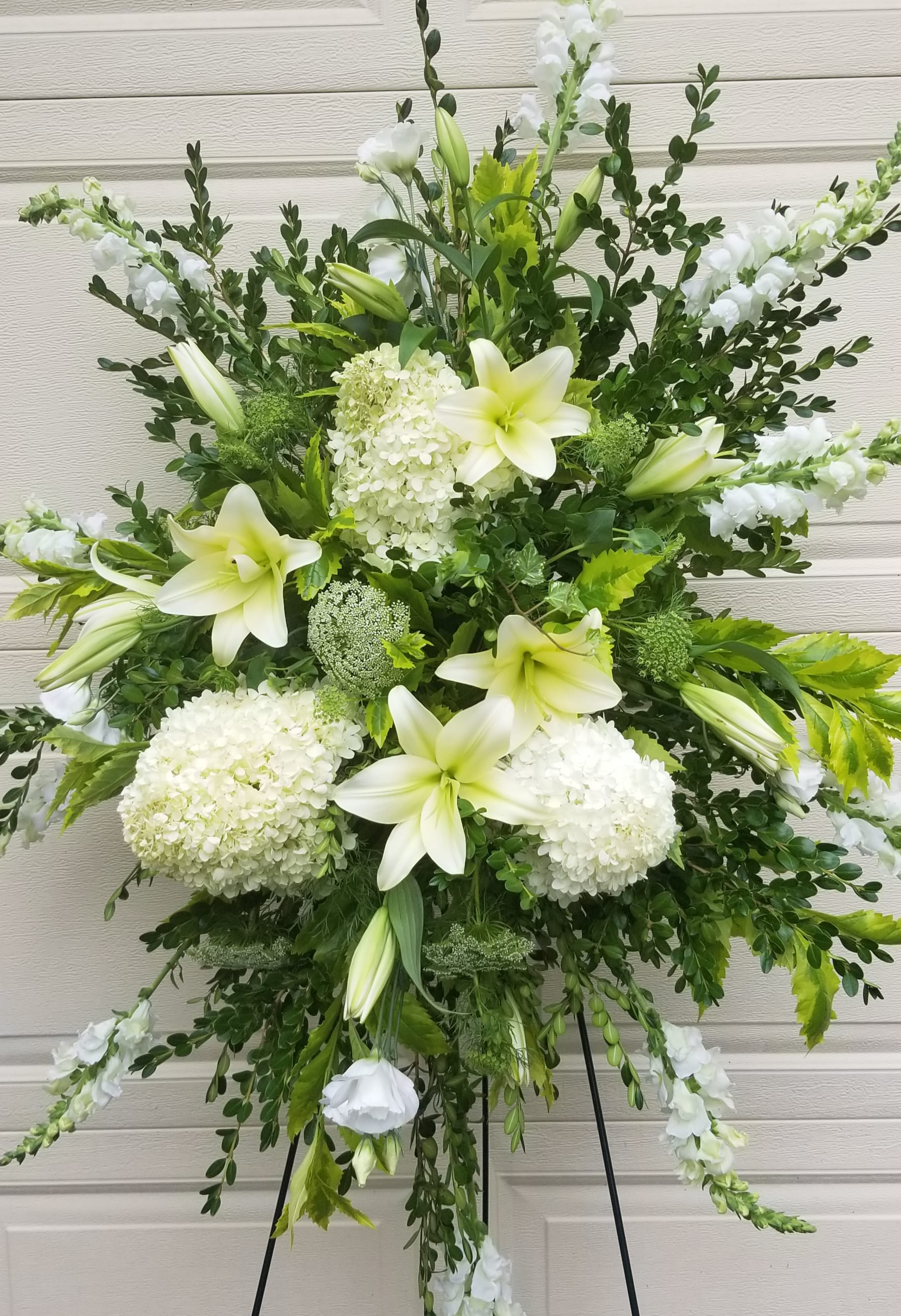 White lilies and hydrangeas in a large standing spray