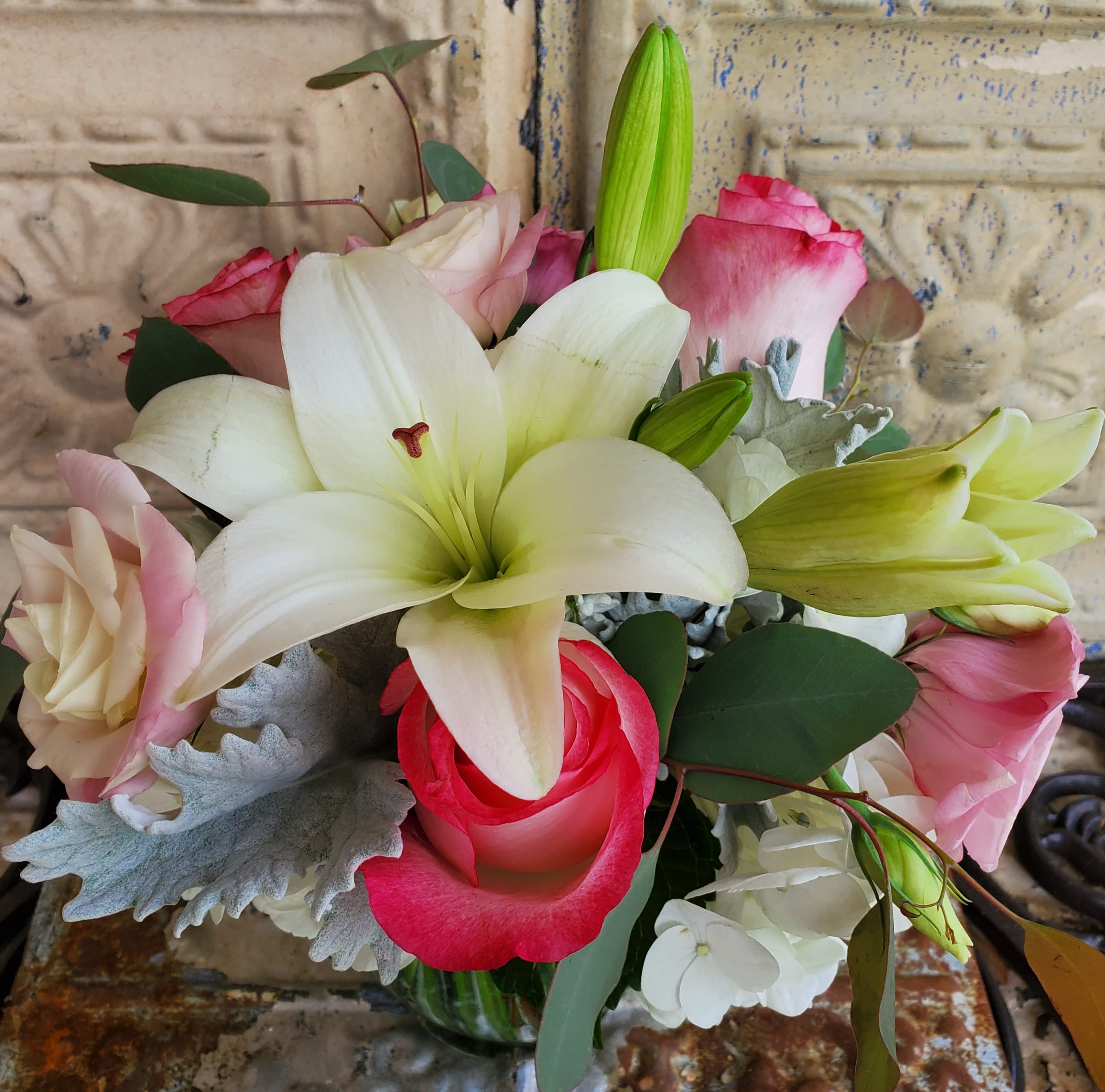 Bouquet of white lilies and pink roses in a glass vase