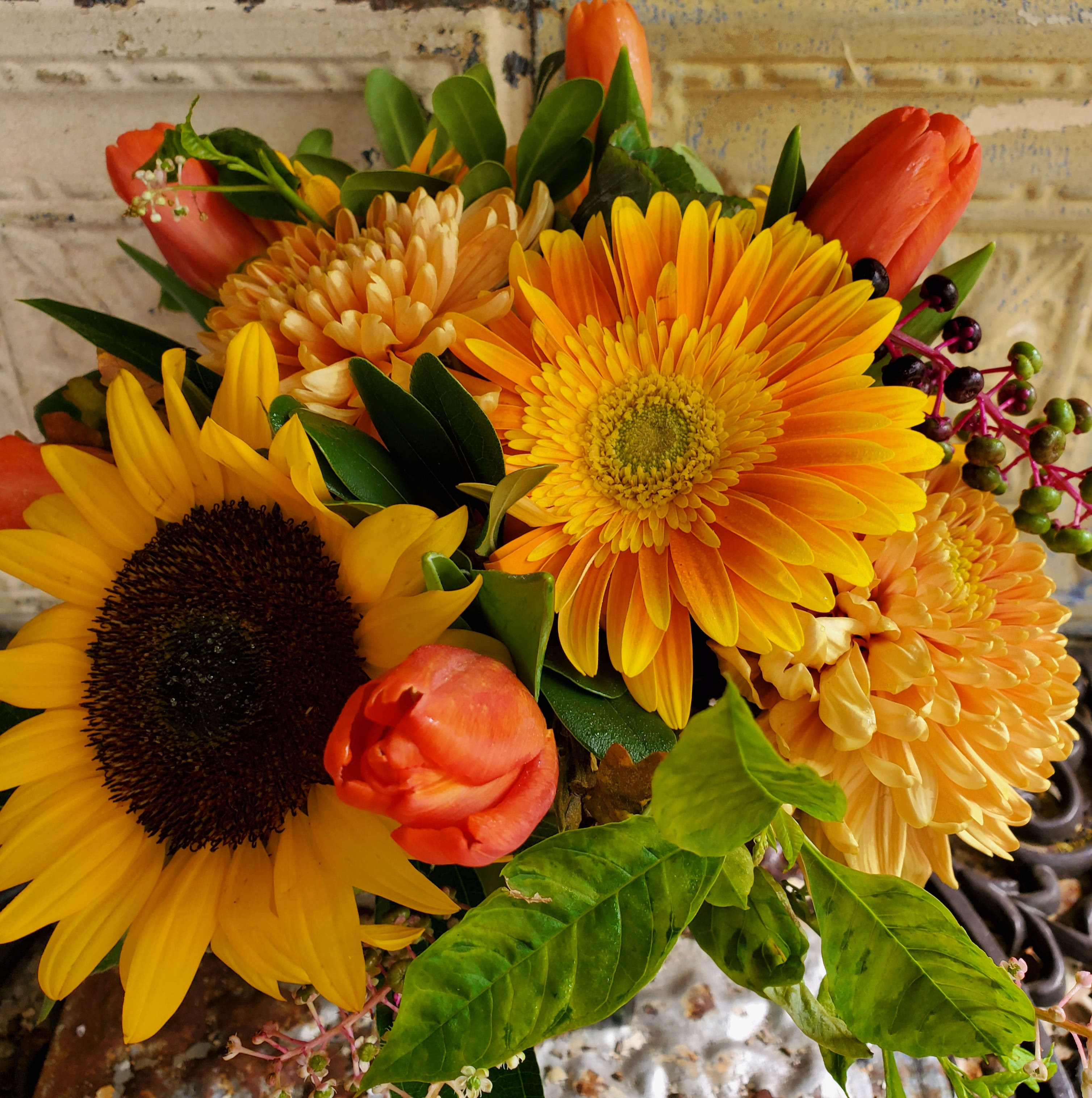 Bouquet of yellow sunflowers, orange tulips, and orange mums