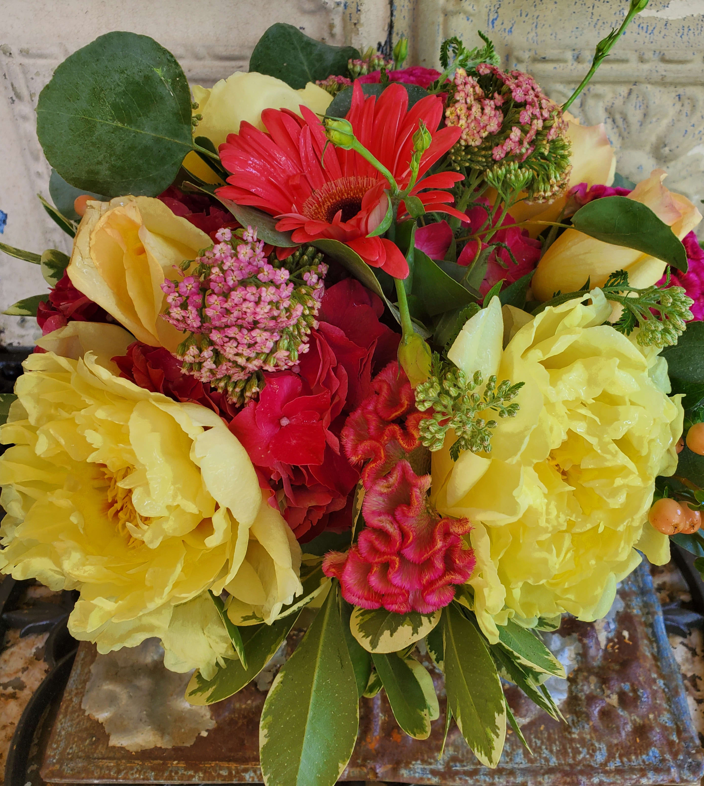 Bouquet of yellow peonies, red gerbera daisies, and pink flowers