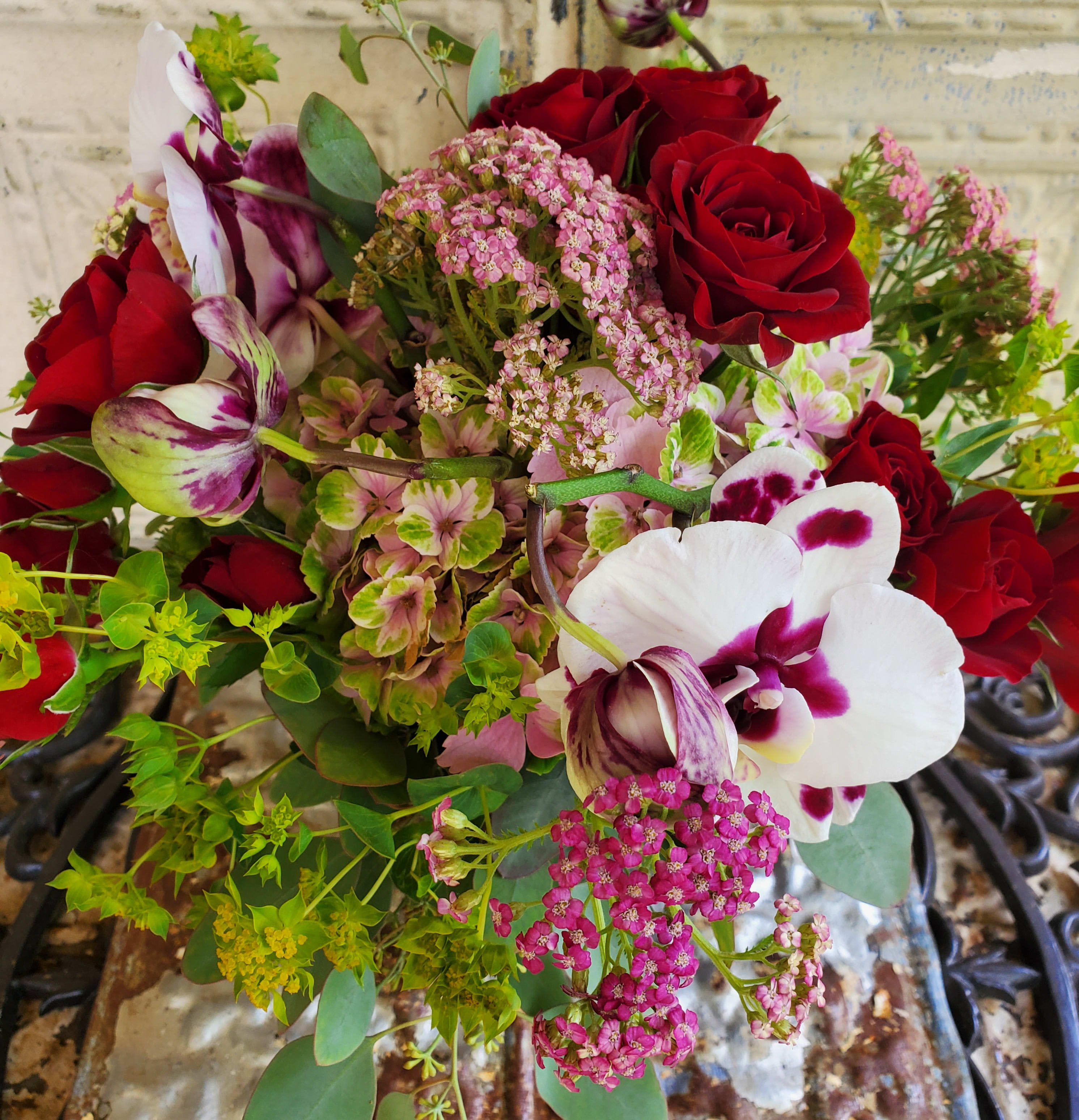 Bouquet of red roses and white-purple orchids with pink filler flowers