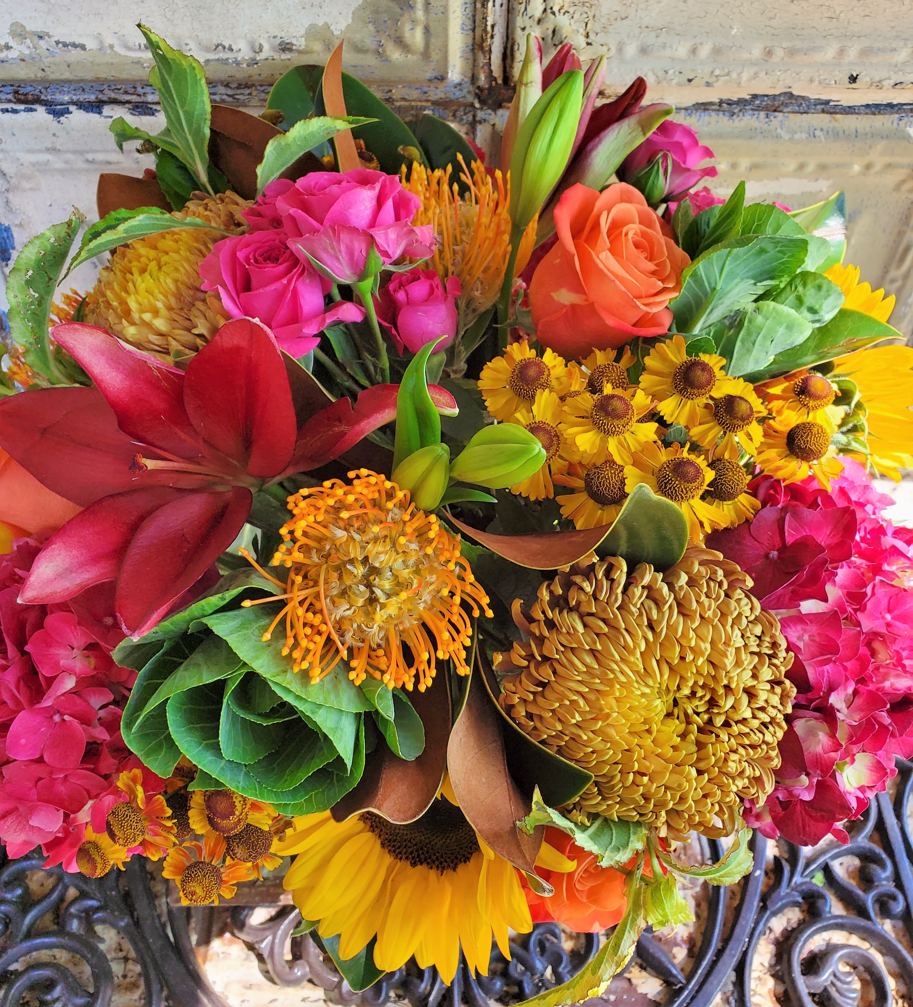 Mixed bouquet with roses, lilies, sunflowers, and orange pincushion blooms