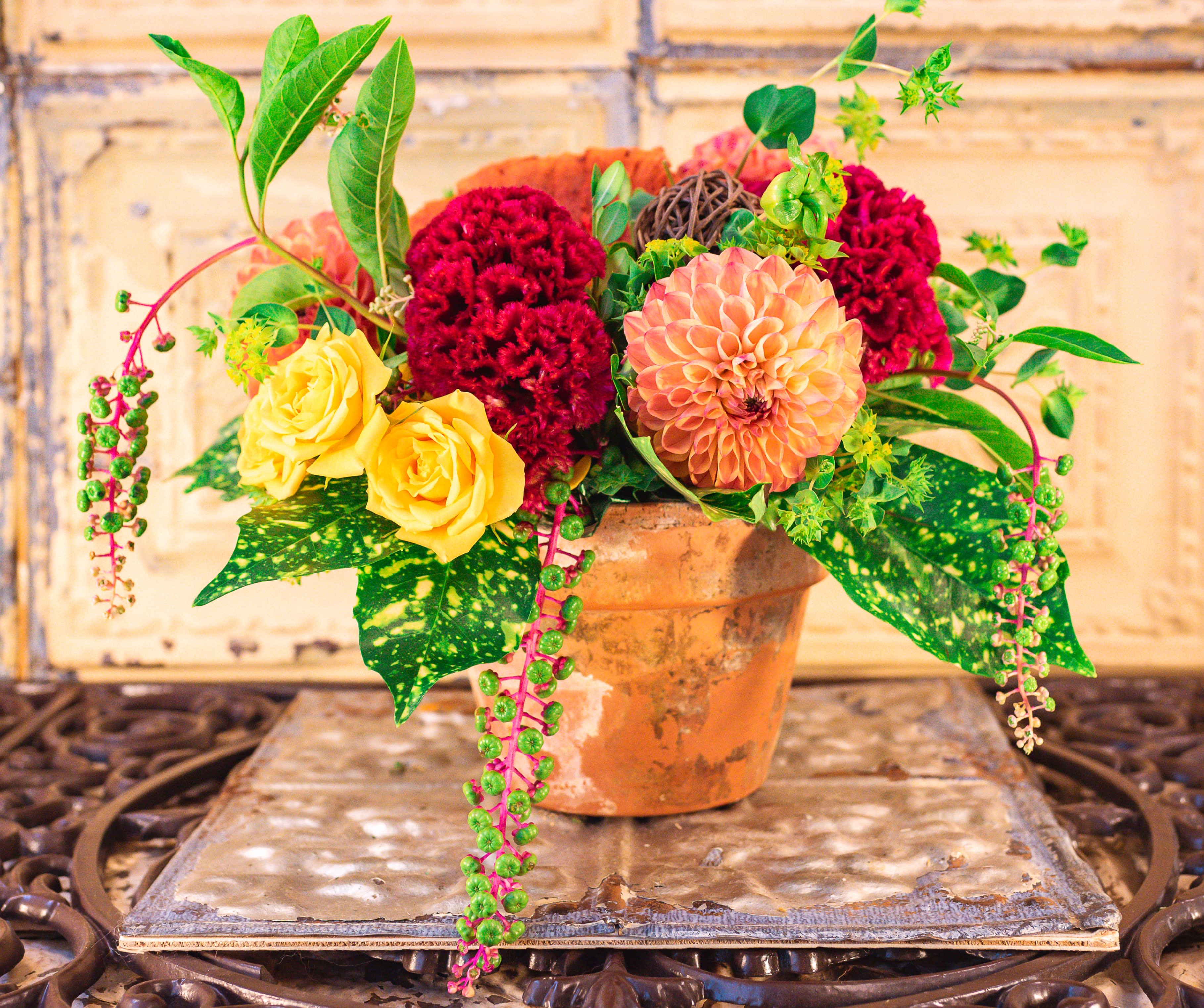 Mixed bouquet in a terracotta pot with yellow roses and red blooms