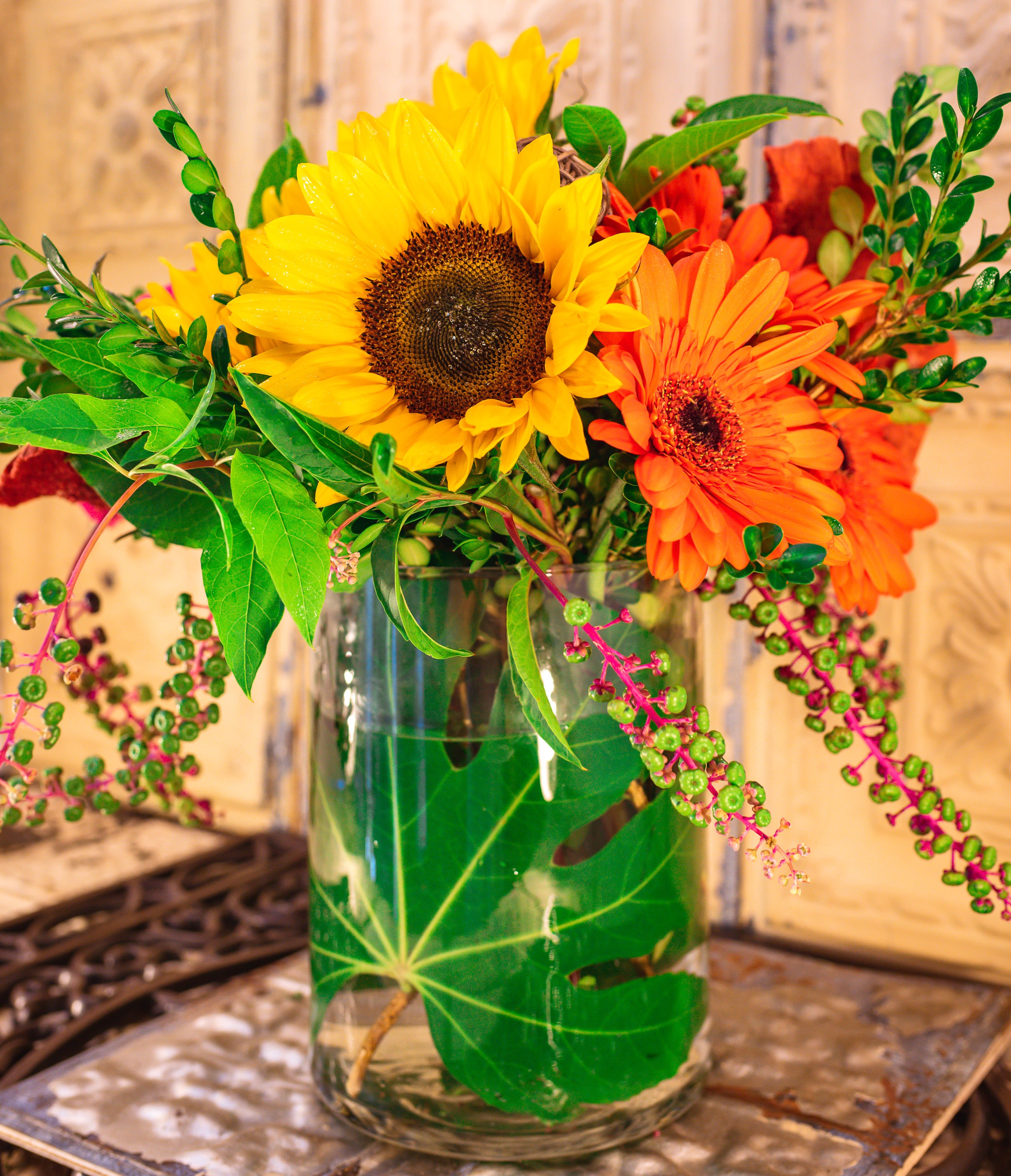 Sunflowers and orange gerbera daisies in a glass vase
