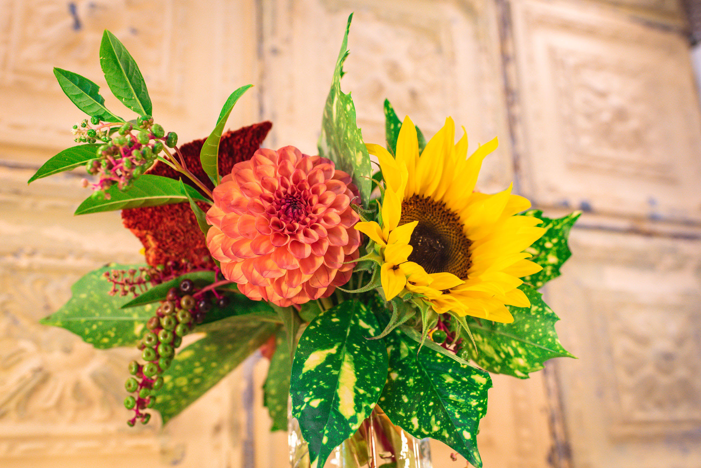 Bouquet with a coral dahlia and yellow sunflower in a glass vase