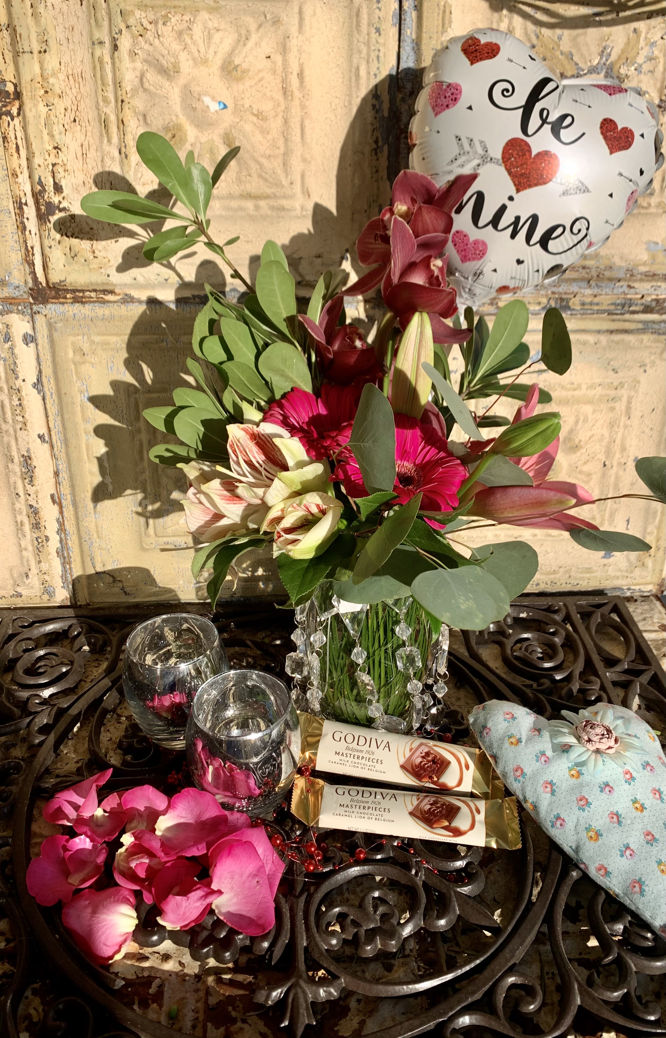 Bouquet with pink and burgundy flowers, chocolates, and a heart balloon