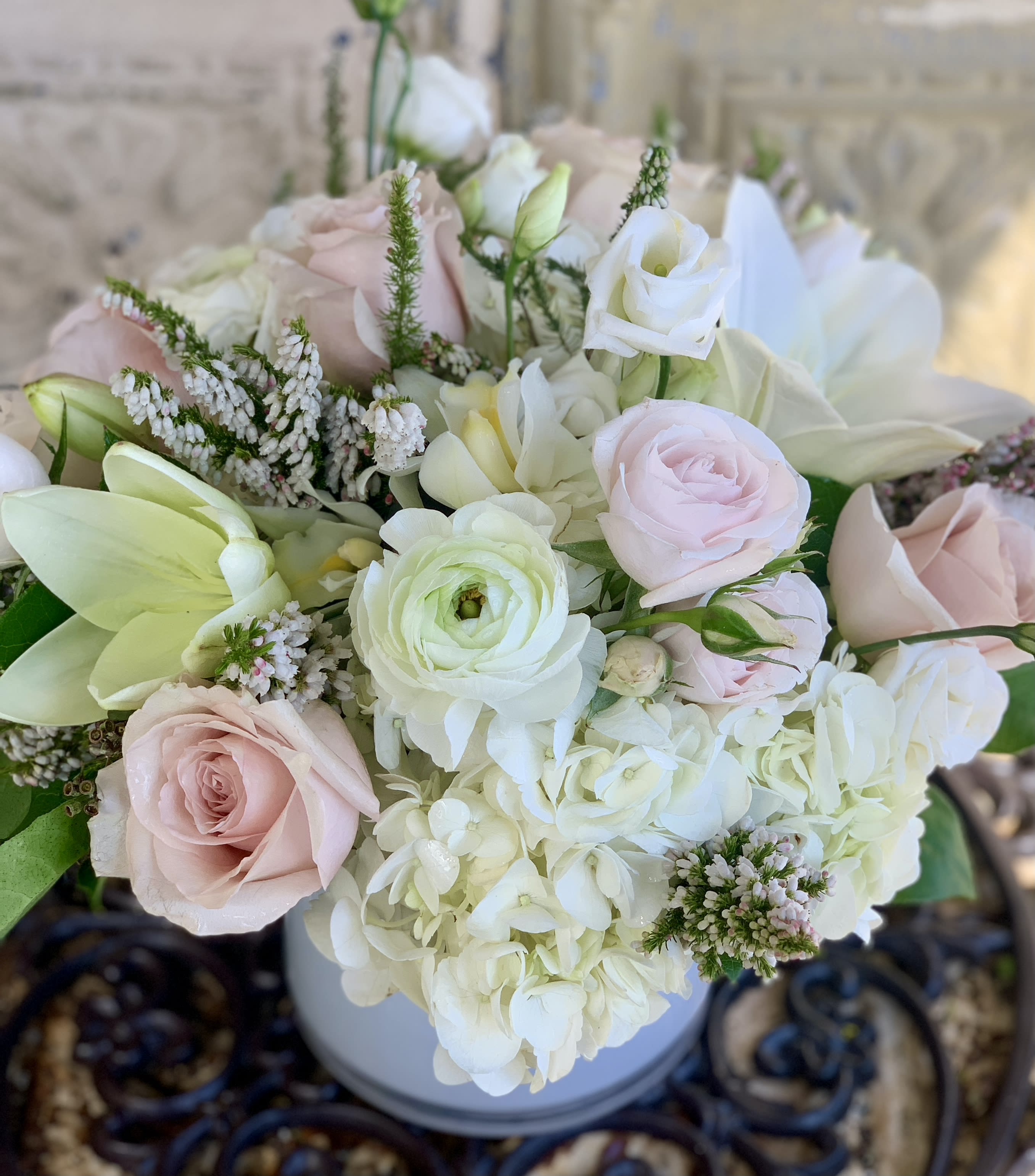 Blush and white bouquet with roses, lilies, and hydrangea in a vase