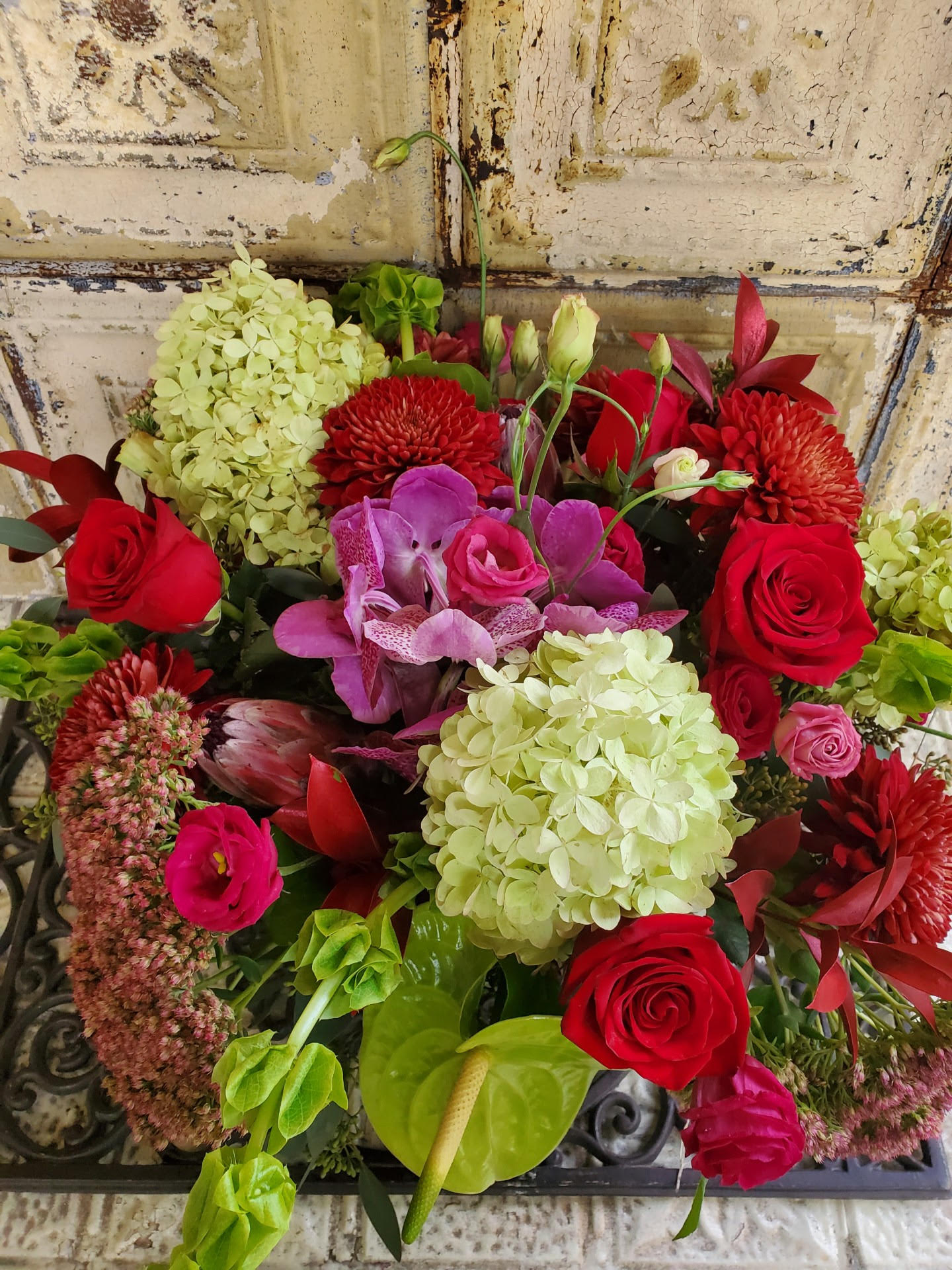 Bouquet of red roses, pink orchids, and pale hydrangeas
