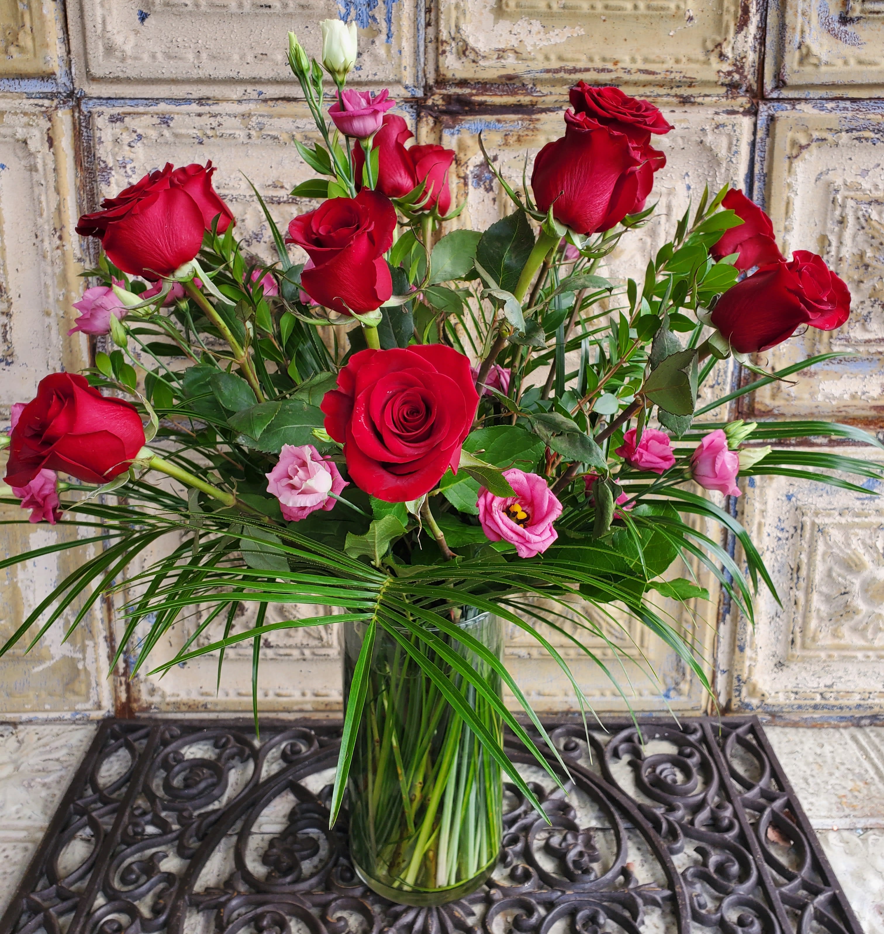 Red roses and pink lisianthus in a clear glass vase
