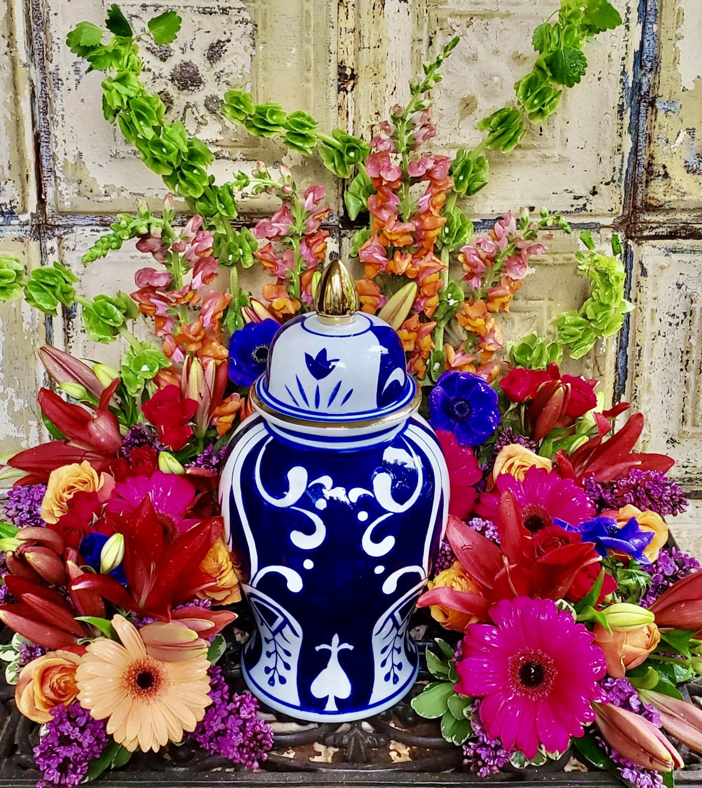Colorful floral arrangement around a blue-and-white ceramic urn