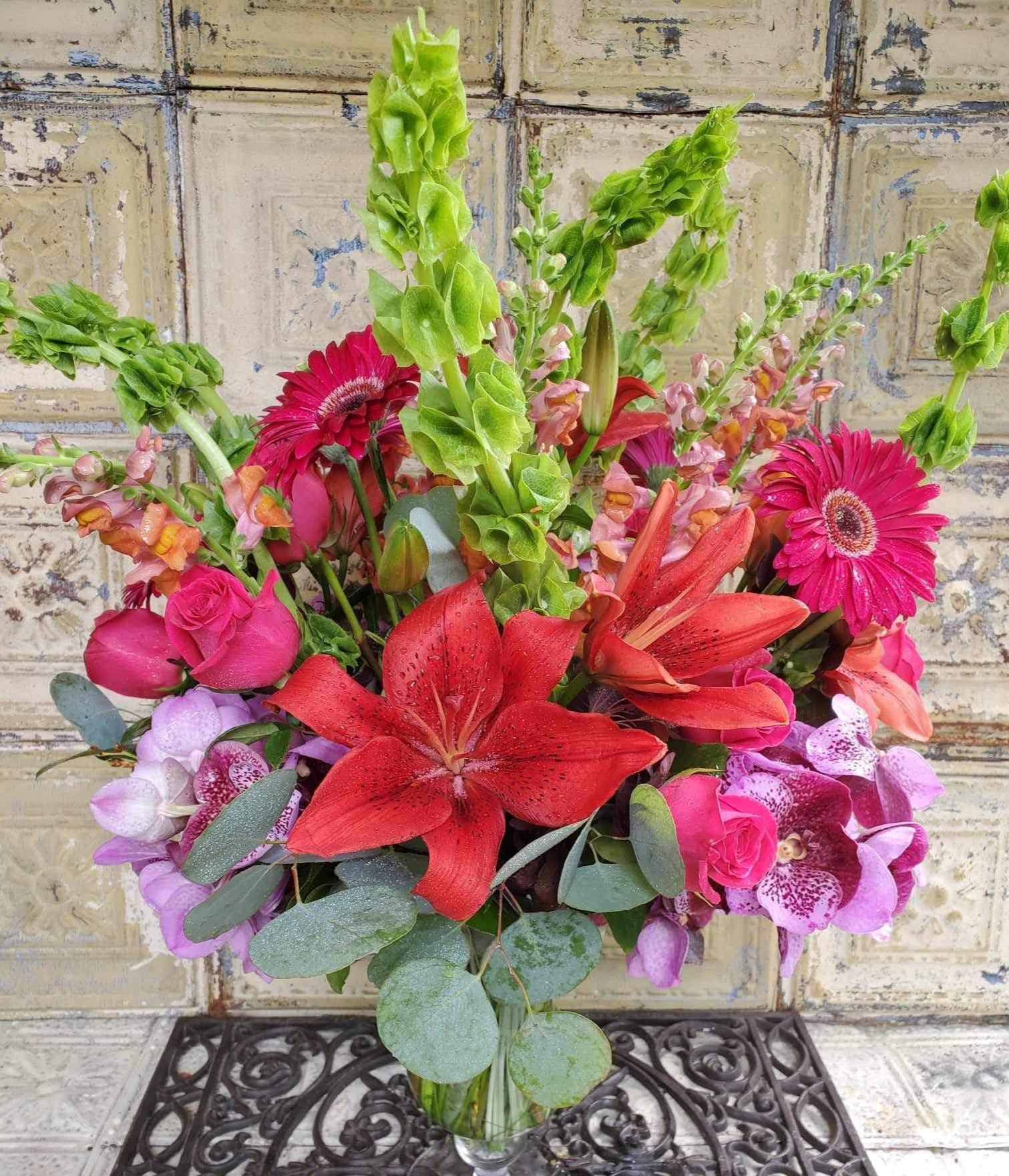 Mixed bouquet with red lilies, pink roses, gerbera daisies, and purple orchids