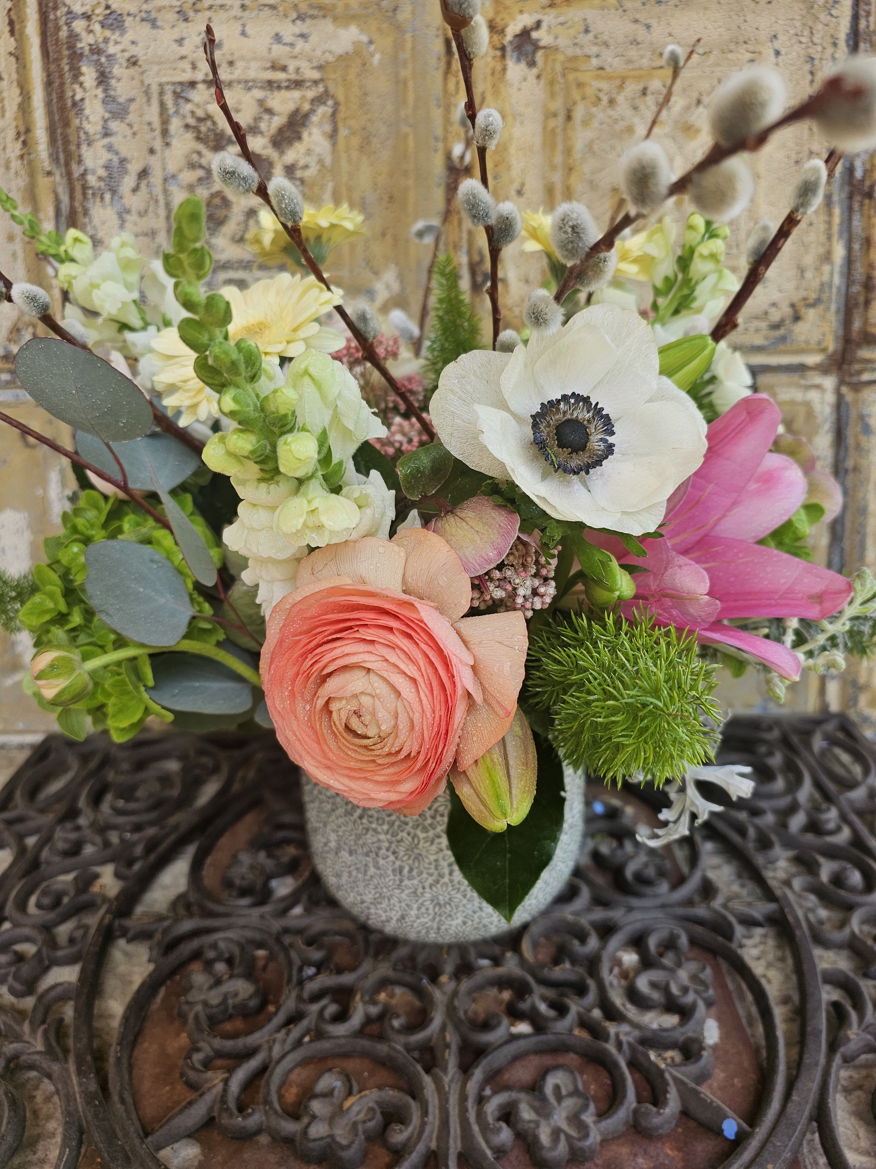 Mixed bouquet in a gray vase with pink, white, and yellow blooms
