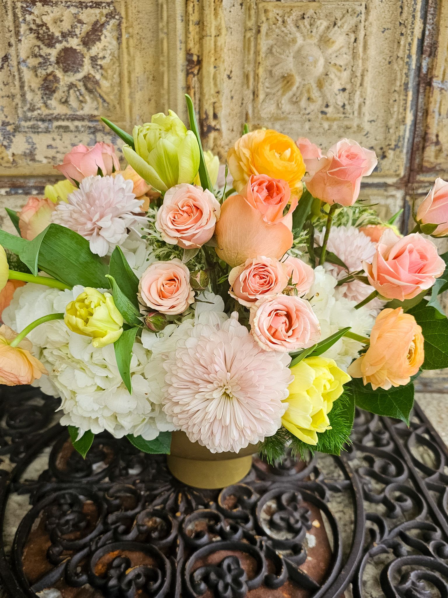 Pastel bouquet of roses, tulips, and chrysanthemums in a low vase