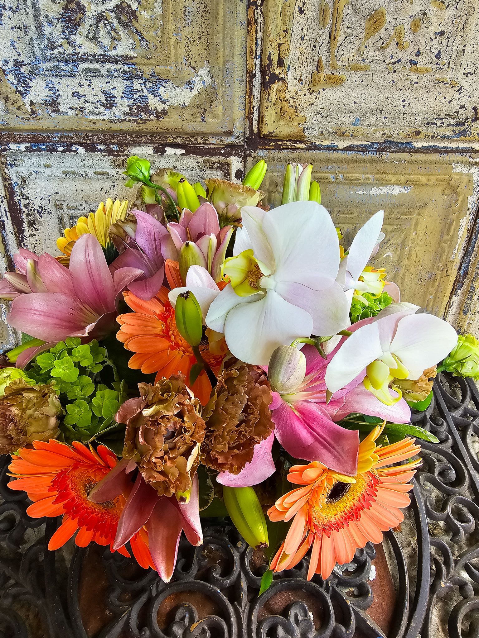 Mixed bouquet with white orchids, pink lilies, and orange gerbera daisies