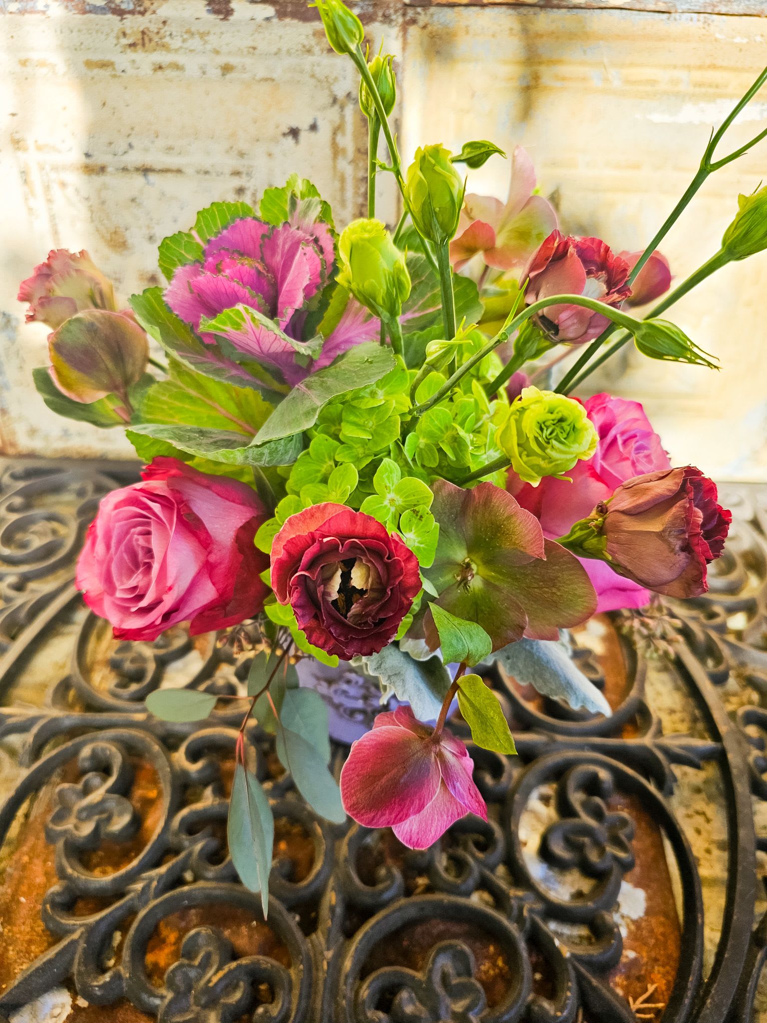 Bouquet of pink roses and green blooms in a vase