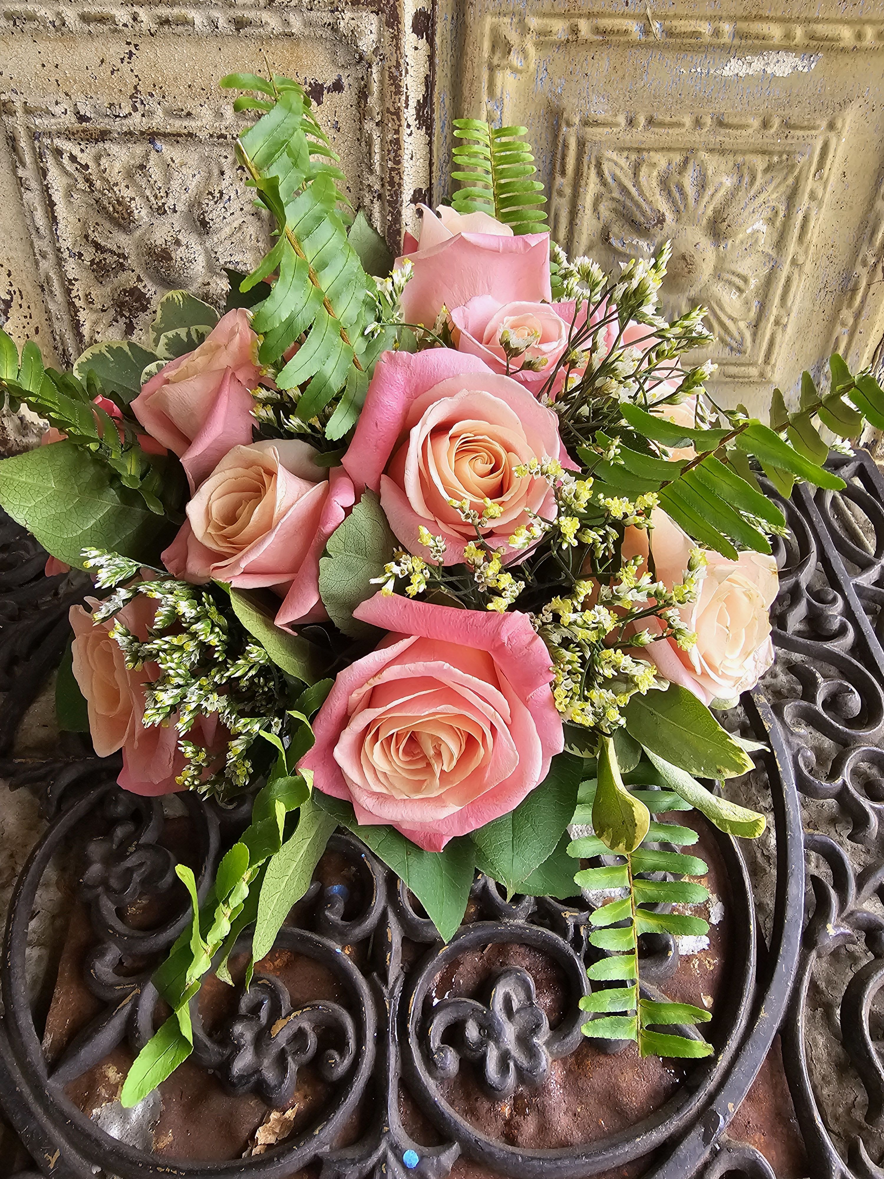 Pink and peach rose bouquet with fern and small white filler flowers