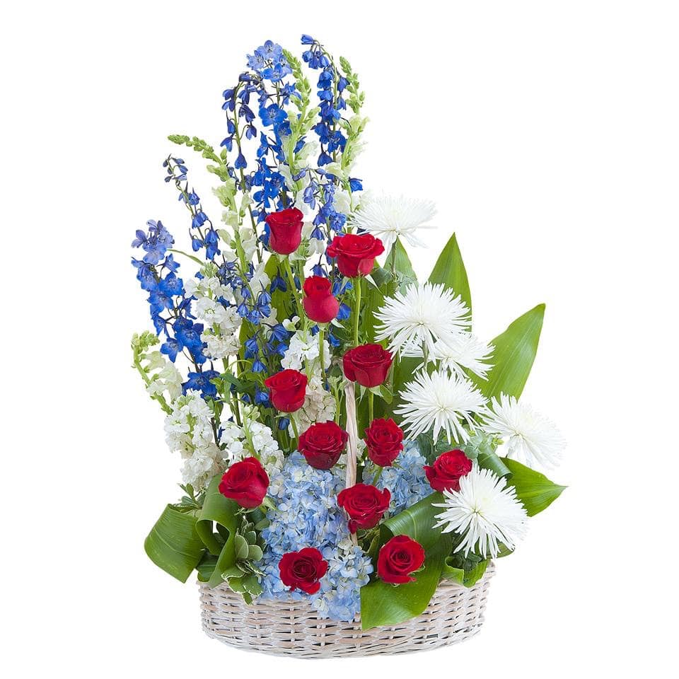 Basket arrangement of red roses, blue and white flowers, and white spider mums