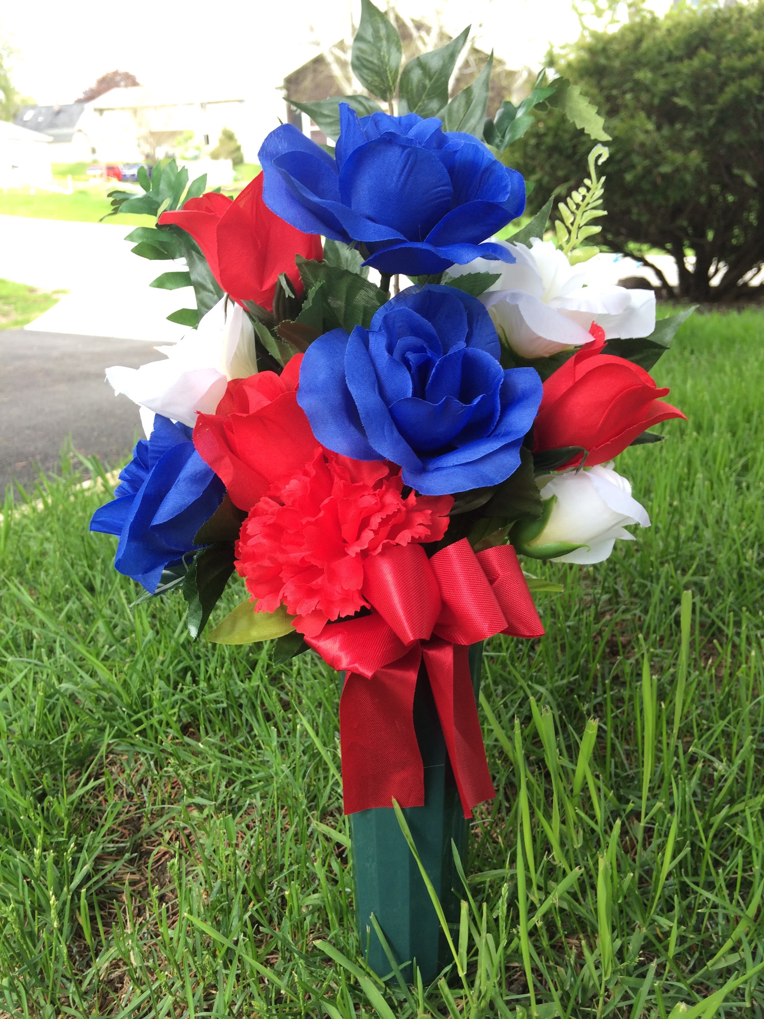 Patriotic Silk Bouquet (cemetery memorial) - Red, White &amp; Blue silk flowers come together with silk greenery &amp; a ribbon in a plastic vase with an insert pin included. Inventory count: 2 remaining.