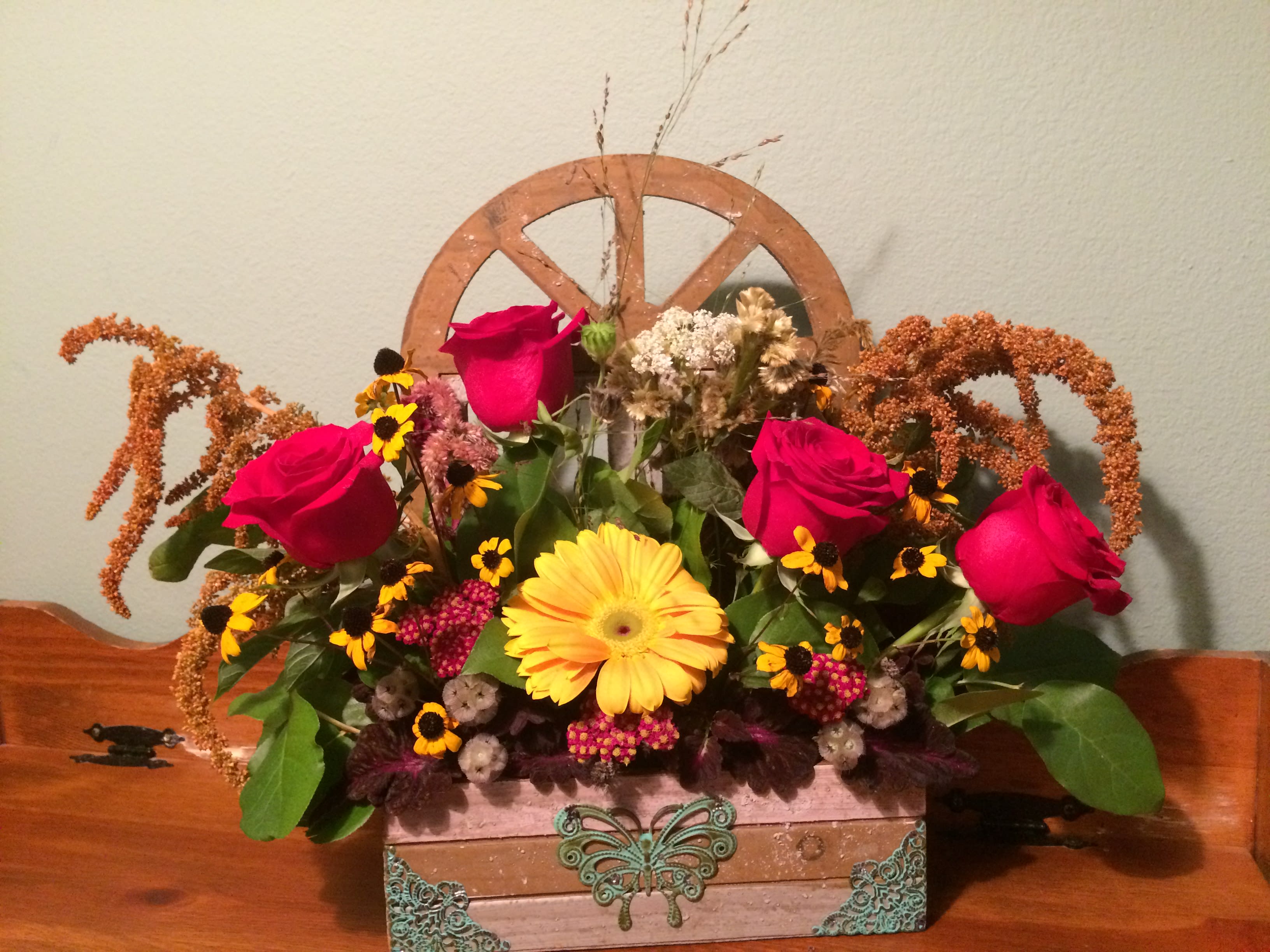 Mixed bouquet with red roses and a yellow gerbera daisy in a decorative box