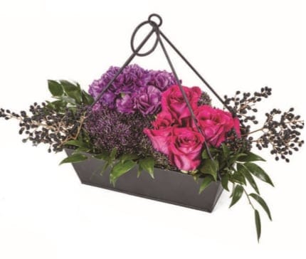 Pink and purple roses in a black handled basket