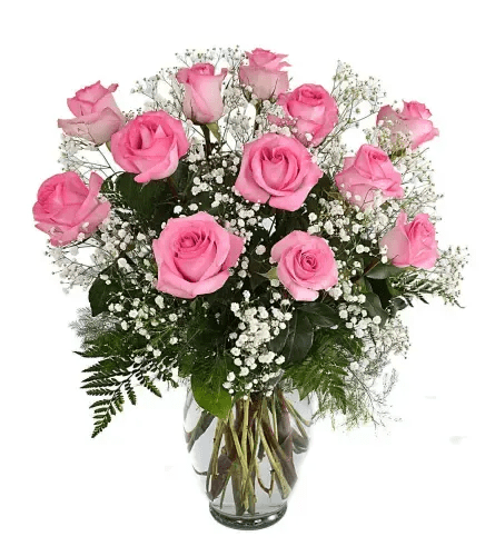 Pink roses arranged in a clear glass vase with baby's breath