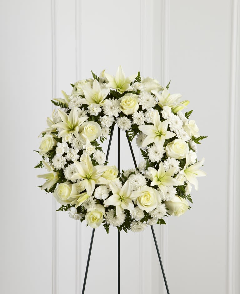 White floral wreath on a black stand