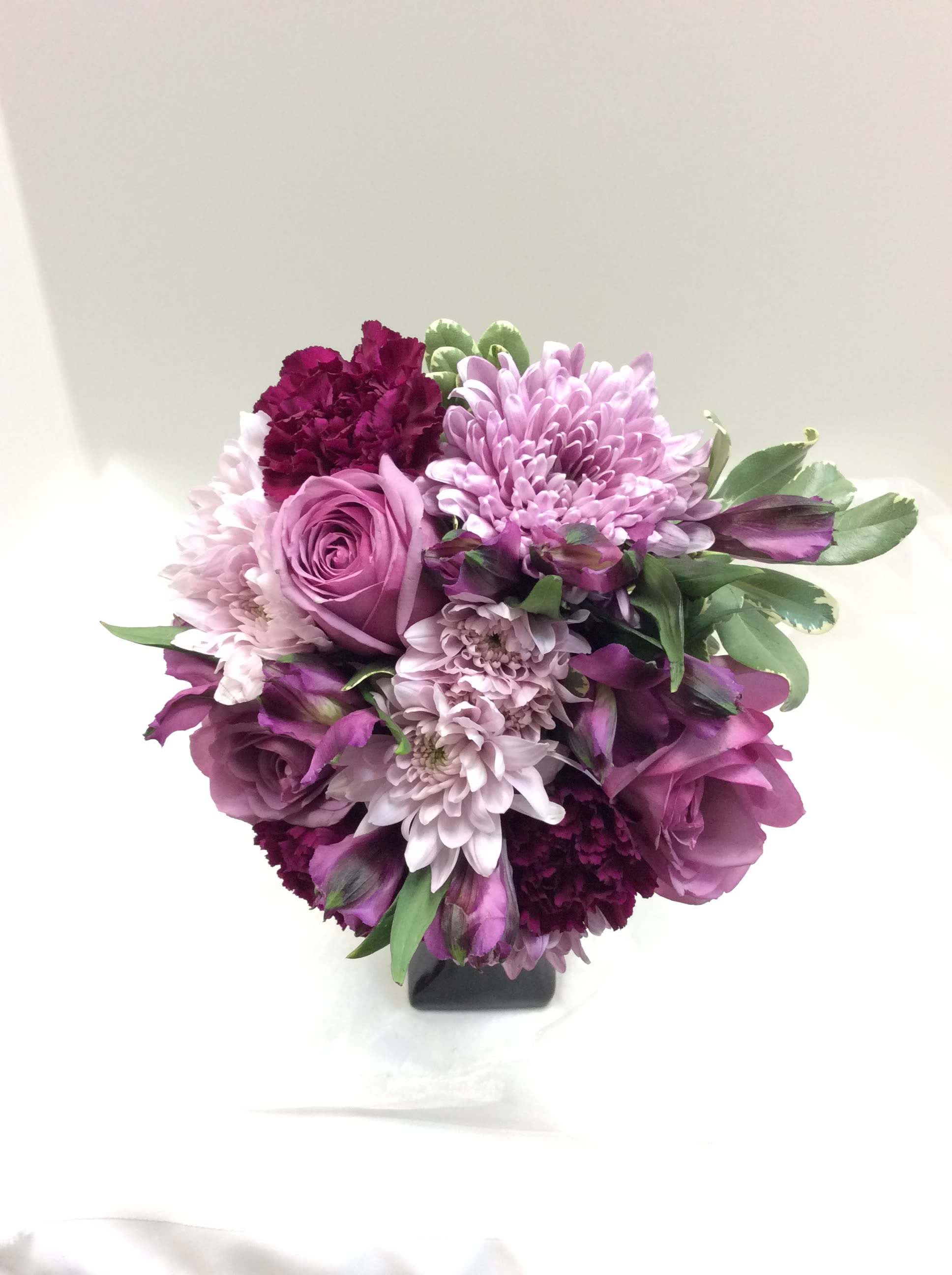 Purple and pink bouquet in a black vase